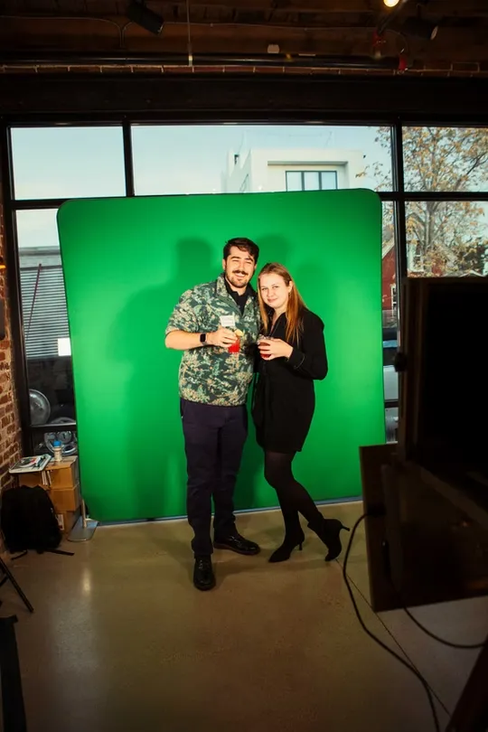 Gamers posing with neon arcade graphics green screen photo booth