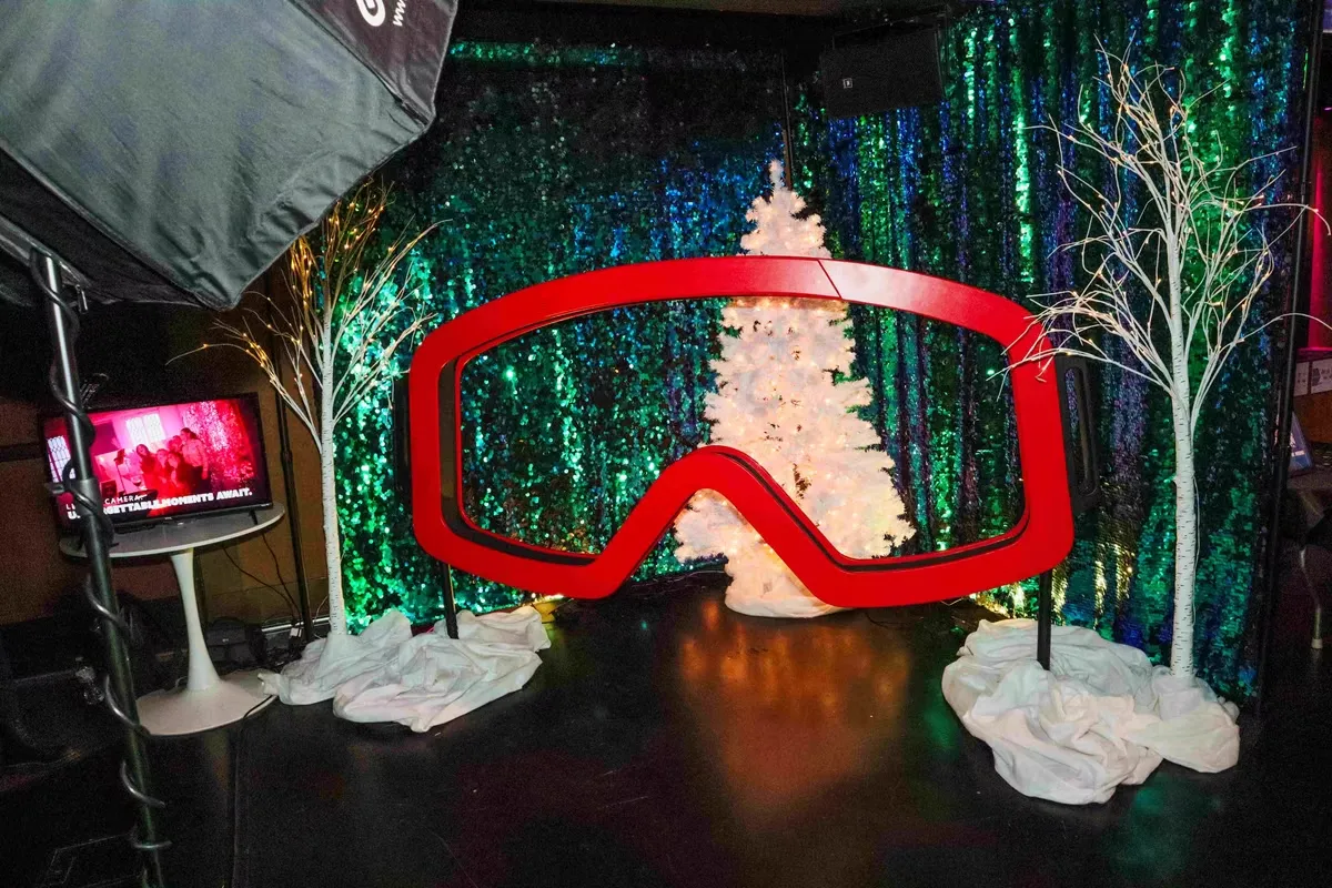 Adventure photo booth with ski goggle theme and vibrant lighting creating fun interactive experience