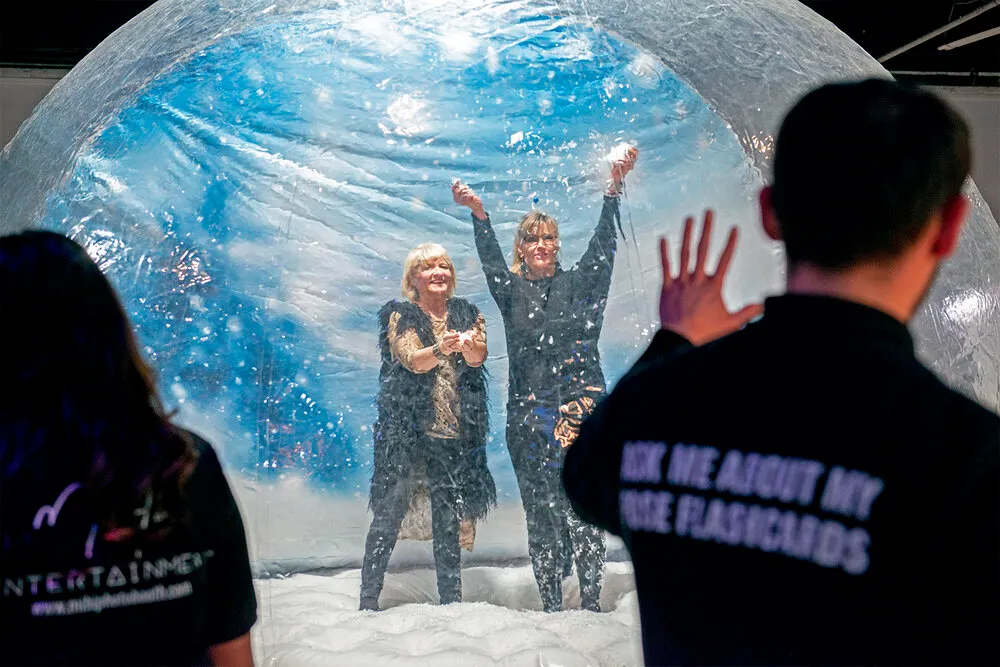 Snow globe photo booth with GIF and Boomerang options capturing bouncing guests and snow throws in winter wonderland