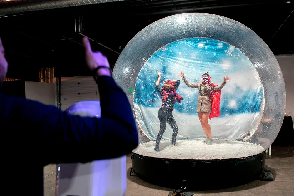 Snow globe photo booth with professional attendants, snow gear props and custom frame designs for winter wonderland events